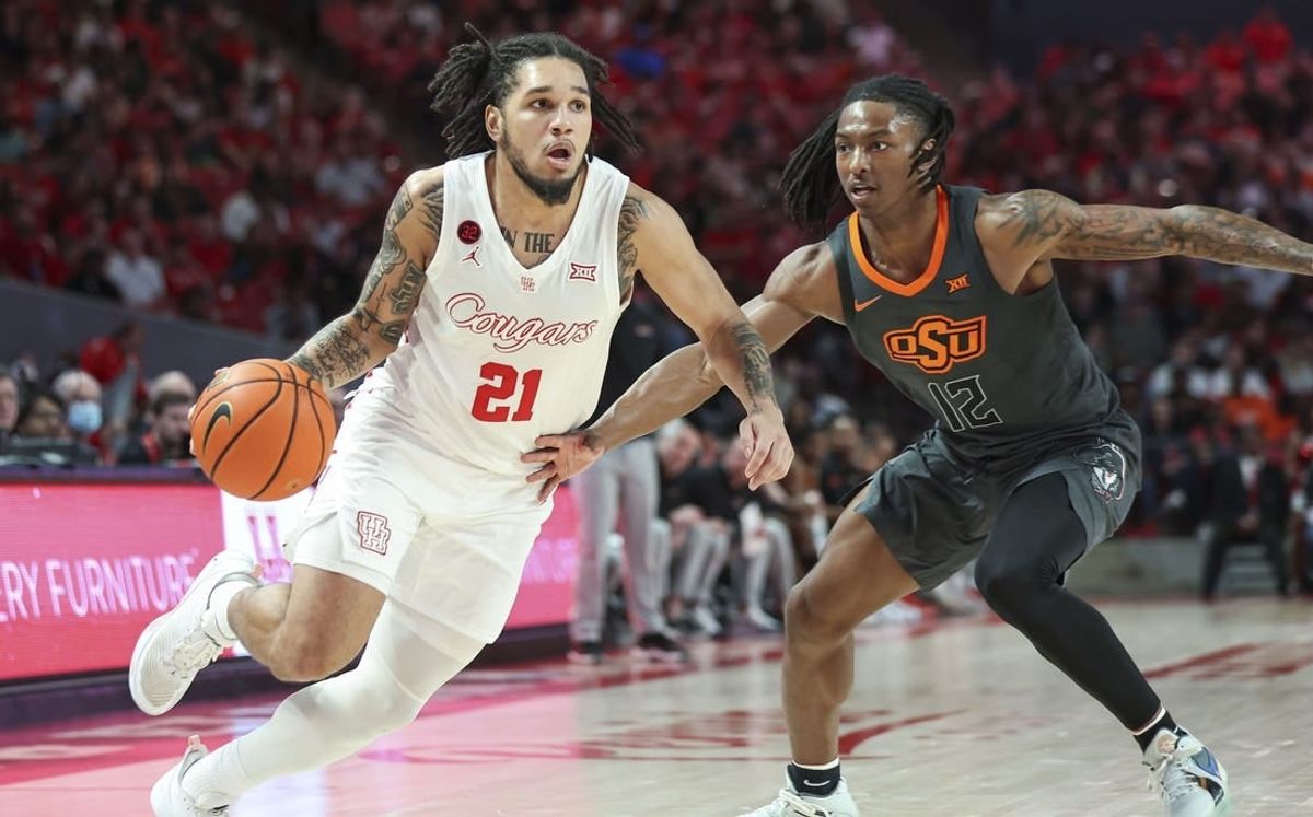Feb 6, 2024; Houston, Texas, USA; Houston Cougars guard Emanuel Sharp (21) drives with the ball as Oklahoma State Cowboys guard Javon Small (12) defends during the second half at Fertitta Center.