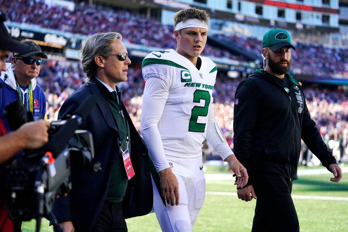 An injured Zach Wilson exits the game on Sunday.