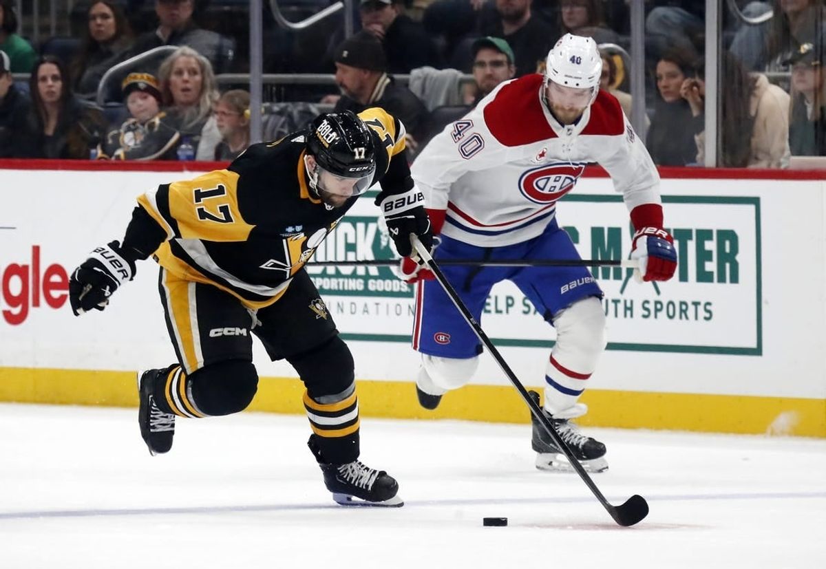 Jan 27, 2024; Pittsburgh, Pennsylvania, USA;  Pittsburgh Penguins right wing Bryan Rust (17) breaks up ice with the puck as Montreal Canadiens right wing Joel Armia (40) chases during the third period at PPG Paints Arena. The Penguins won 3-2 in overtime.