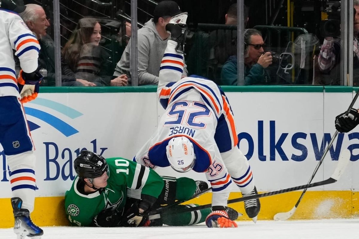 Feb 17, 2024; Dallas, Texas, USA;  Edmonton Oilers defenseman Darnell Nurse (25) is checked by Dallas Stars center Ty Dellandrea (10) during the first period at American Airlines Center.