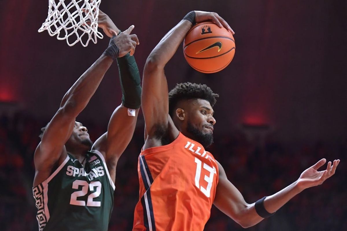 Jan 11, 2024; Champaign, Illinois, USA;  Illinois Fighting Illini forward Quincy Guerrier (13) pulls down a rebound in front of Michigan State Spartans center Mady Sissoko (22) during the second half at State Farm Center.