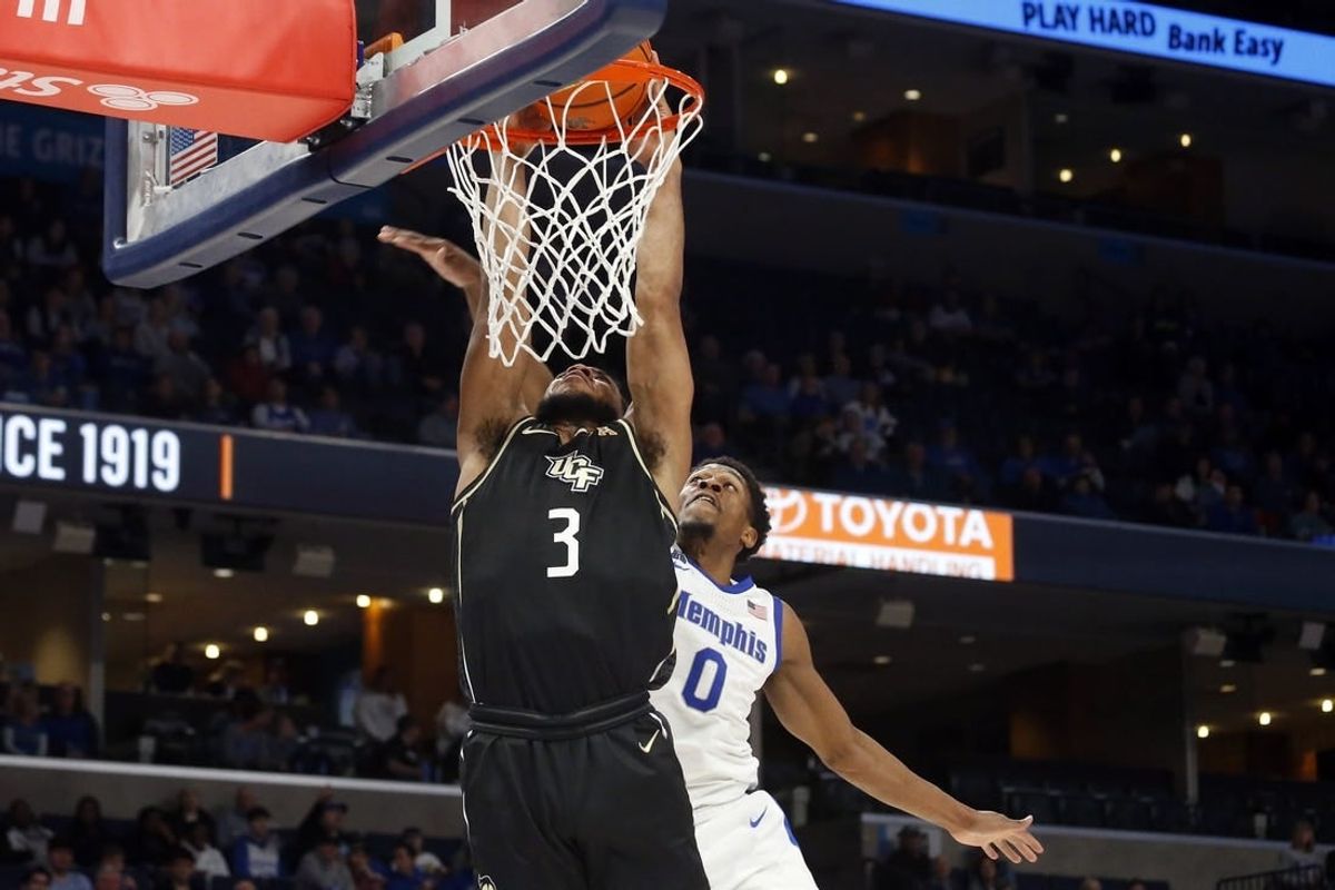 Feb 16, 2023; Memphis, Tennessee, USA; UCF Knights guard Darius Johnson (3) drives to the basket as Memphis Tigers guard Elijah McCadden (0) defends during the second half at FedExForum.