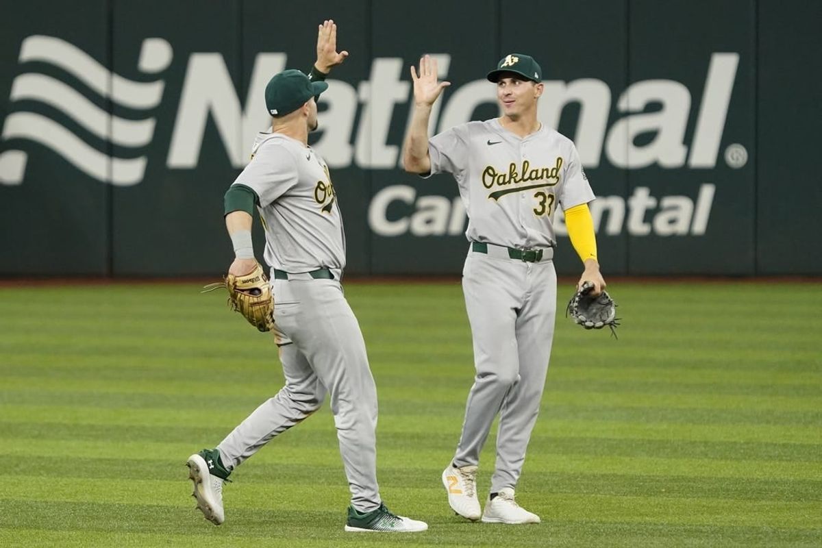 Apr 11, 2024; Arlington, Texas, USA; Oakland Athletics outfielder Seth Brown (15) and outfielder JJ Bleday (33) high five following the game against the Texas Rangers at Globe Life Field.