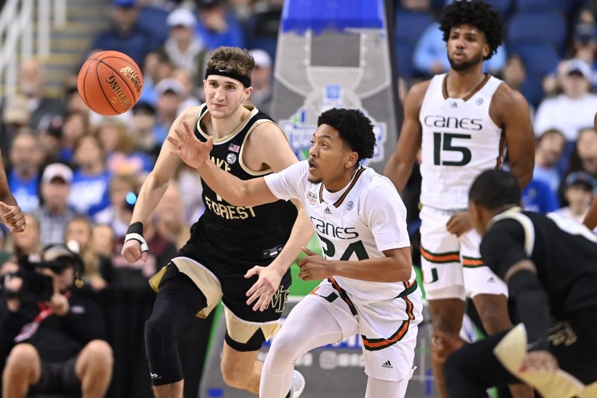 Mar 9, 2023; Greensboro, NC, USA; Miami (Fl) Hurricanes guard Nijel Pack (24) with the ball as Wake Forest Demon Deacons forward Andrew Carr (11) defends during the second half of the quarterfinals of the ACC tournament at Greensboro Coliseum.