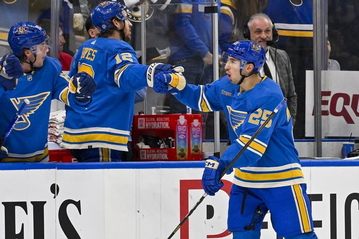 Dec 23, 2023; St. Louis, Missouri, USA;  St. Louis Blues center Jordan Kyrou (25) is congratulated by right wing Kevin Hayes (12) and left wing Jake Neighbours (63) after scoring against the Chicago Blackhawks during the third period at Enterprise Center.
