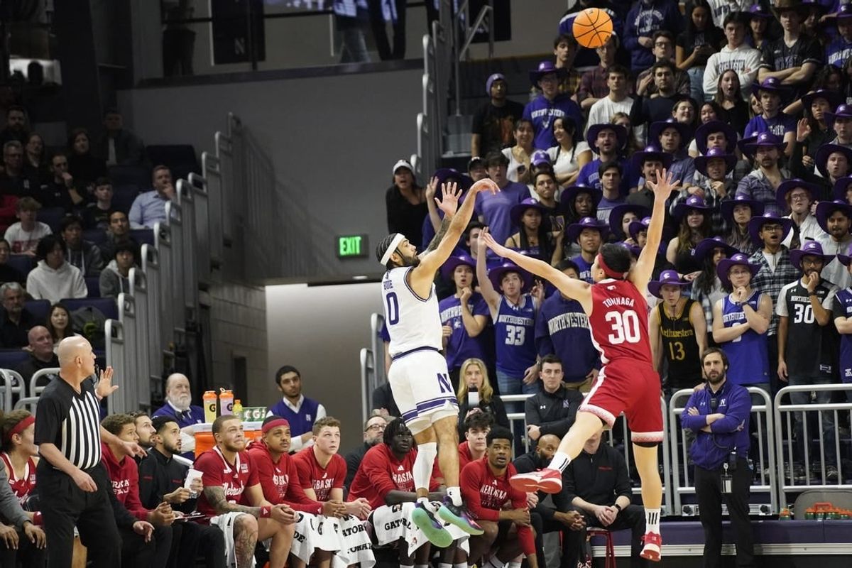 Feb 7, 2024; Evanston, Illinois, USA; Northwestern Wildcats guard Boo Buie (0) makes a three point basket over Nebraska Cornhuskers guard Keisei Tominaga (30)during the first half at Welsh-Ryan Arena.