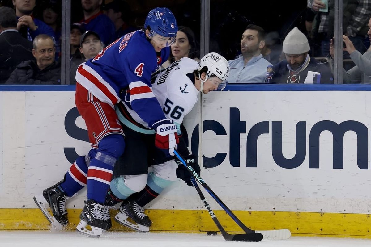 Jan 16, 2024; New York, New York, USA; New York Rangers defenseman Braden Schneider (4) fights for the puck against Seattle Kraken right wing Kailer Yamamoto (56) during the second period at Madison Square Garden.