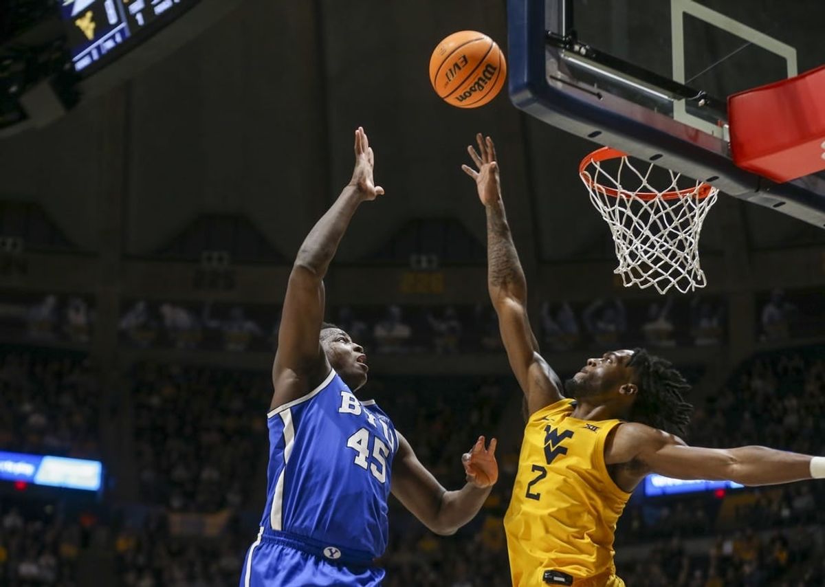 Feb 3, 2024; Morgantown, West Virginia, USA; Brigham Young Cougars forward Fousseyni Traore (45) shoots over West Virginia Mountaineers guard Kobe Johnson (2) during the first half at WVU Coliseum.