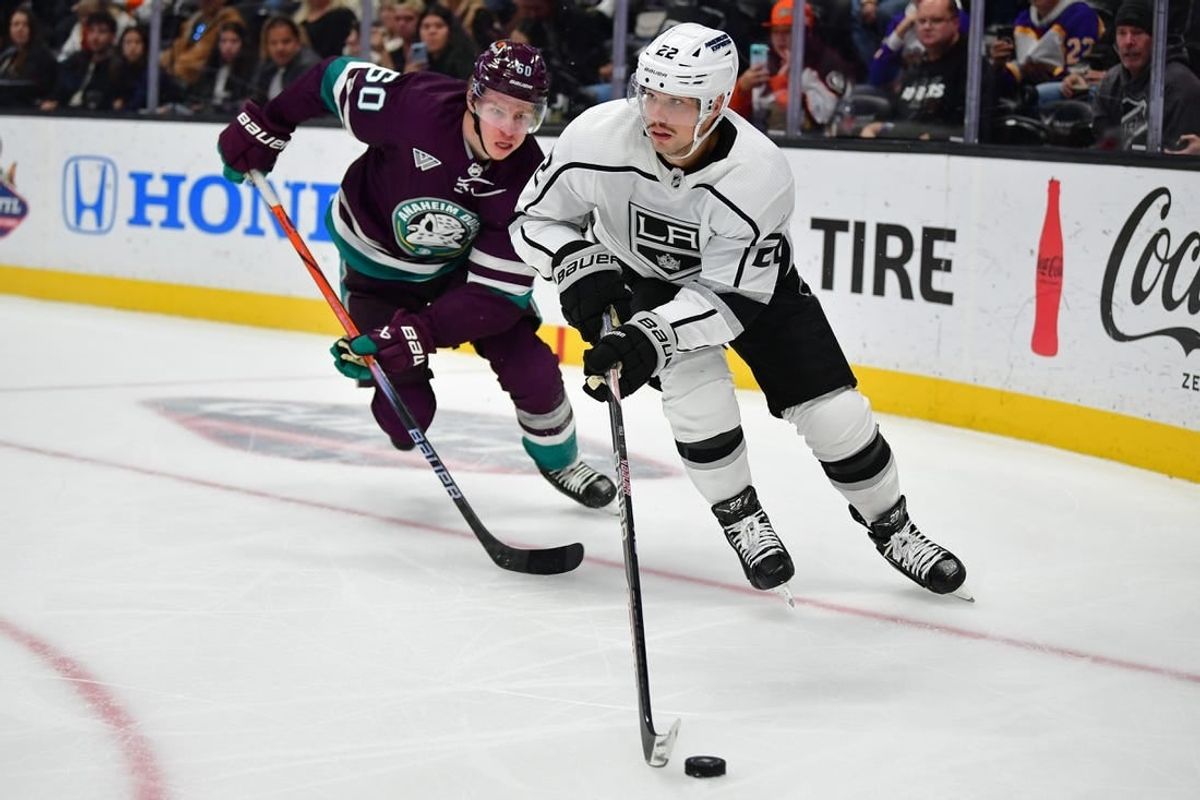 Nov 24, 2023; Anaheim, California, USA; Los Angeles Kings left wing Kevin Fiala (22) moves the puck ahead of Anaheim Ducks defenseman Jackson LaCombe (60) during the third period at Honda Center.