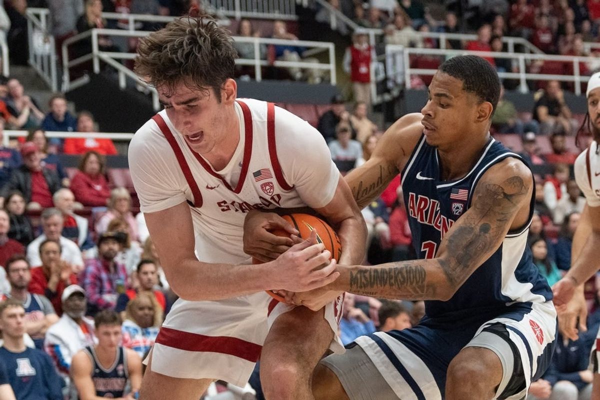 Dec 31, 2023; Stanford, California, USA; Stanford Cardinal forward Maxime Raynaud (42) and Arizona Wildcats forward Keshad Johnson (16) fight for control of the ball during the second half at Maples Pavilion.