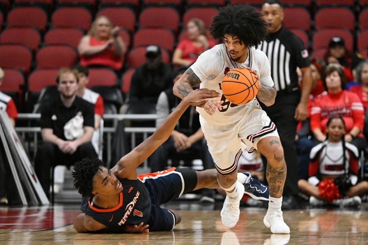 Dec 17, 2023; Louisville, Kentucky, USA;  Louisville Cardinals guard Skyy Clark (55) dribbles against Pepperdine Waves guard Michael Ajayi (1) during the second half at KFC Yum! Center. Louisville defeated Pepperdine 85-63.