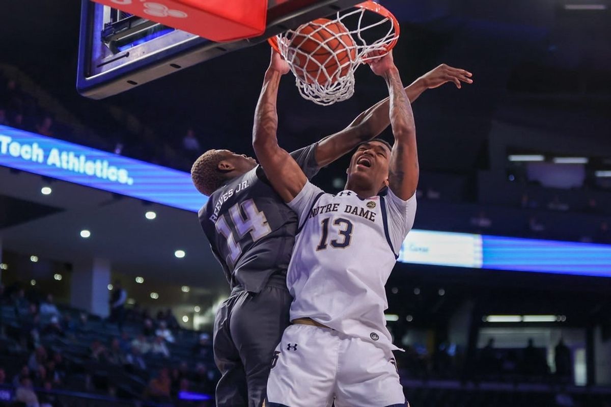 Jan 9, 2024; Atlanta, Georgia, USA; Notre Dame Fighting Irish forward Tae Davis (13) dunks past Georgia Tech Yellow Jackets guard Kowacie Reeves Jr. (14) in the first half at McCamish Pavilion.