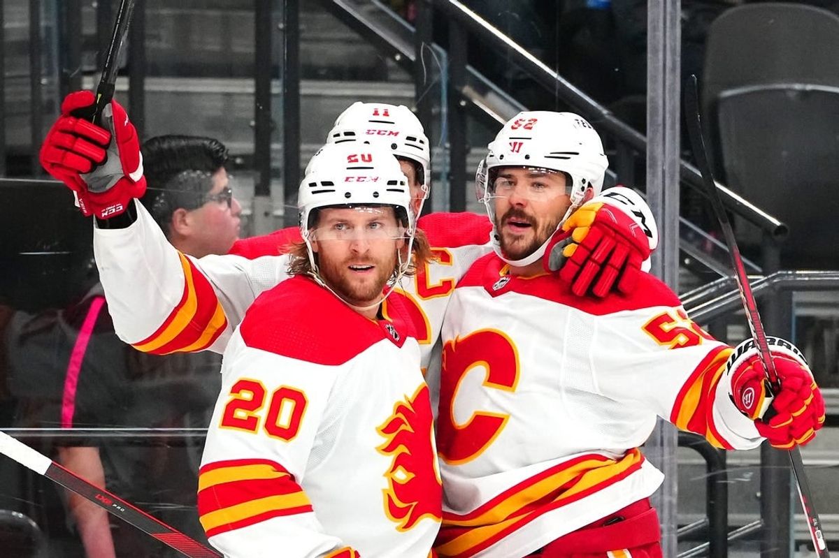 Dec 12, 2023; Las Vegas, Nevada, USA; Calgary Flames defenseman MacKenzie Weegar (52) celebrates with Calgary Flames center Mikael Backlund (11) and Calgary Flames center Blake Coleman (20) after scoring a goal against the Vegas Golden Knights during the first period at T-Mobile Arena.