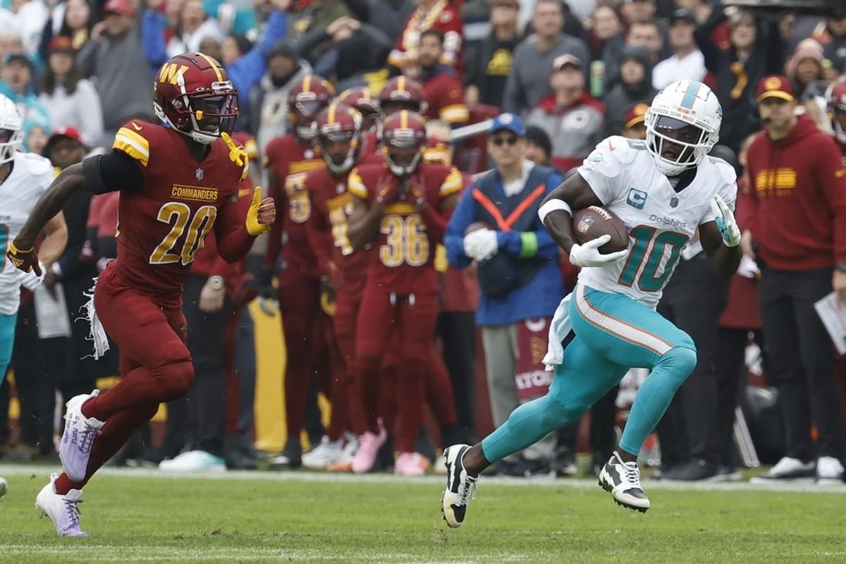 Dec 3, 2023; Landover, Maryland, USA; Miami Dolphins wide receiver Tyreek Hill (10) runs with the ball en route to a touchdown as Washington Commanders safety Jartavius Martin (20) chases during the first quarter at FedExField.