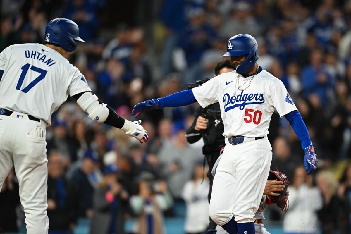 Mar 29, 2024; Los Angeles, California, USA; Los Angeles Dodgers second baseman Mookie Betts (50) hit fives designated hitter Shohei Ohtani (17)after hitting a home run against the St. Louis Cardinals during the first inning at Dodger Stadium.