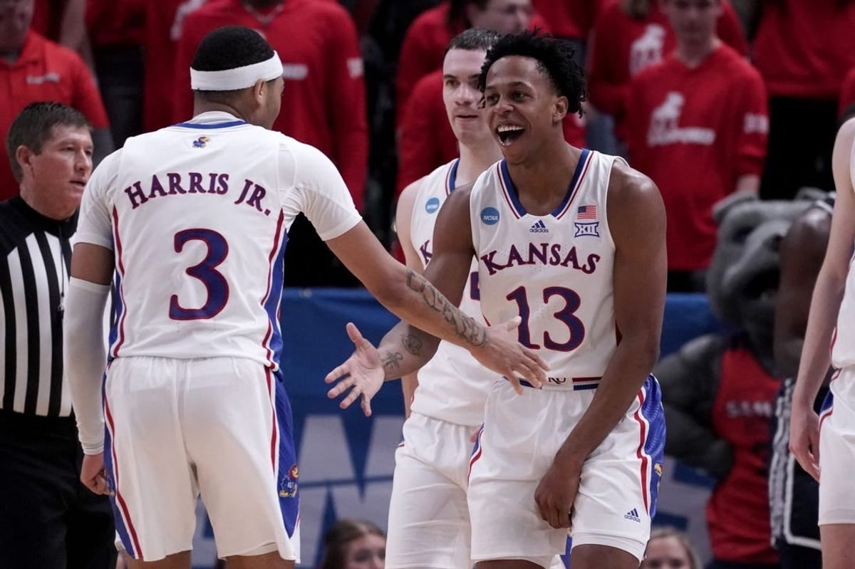Mar 21, 2024; Salt Lake City, UT, USA; Kansas Jayhawks guard Elmarko Jackson (13) celebrates with guard Dajuan Harris Jr. (3) during the second half in the first round of the 2024 NCAA Tournament against the Samford Bulldogs at Vivint Smart Home Arena-Delta Center.