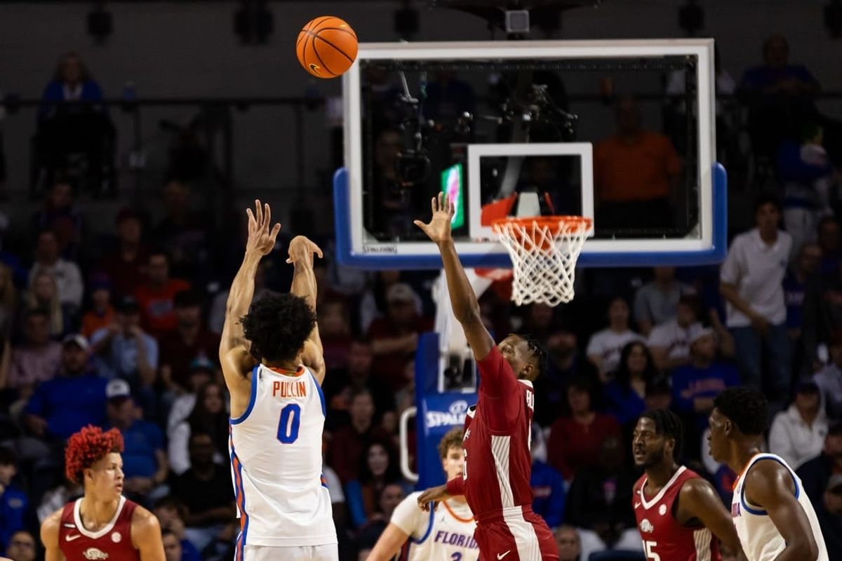 Jan 13, 2024; Gainesville, Florida, USA; Florida Gators guard Zyon Pullin (0) shoots the ball over Arkansas Razorbacks guard Layden Blocker (6) during the first half at Exactech Arena at the Stephen C. O'Connell Center.