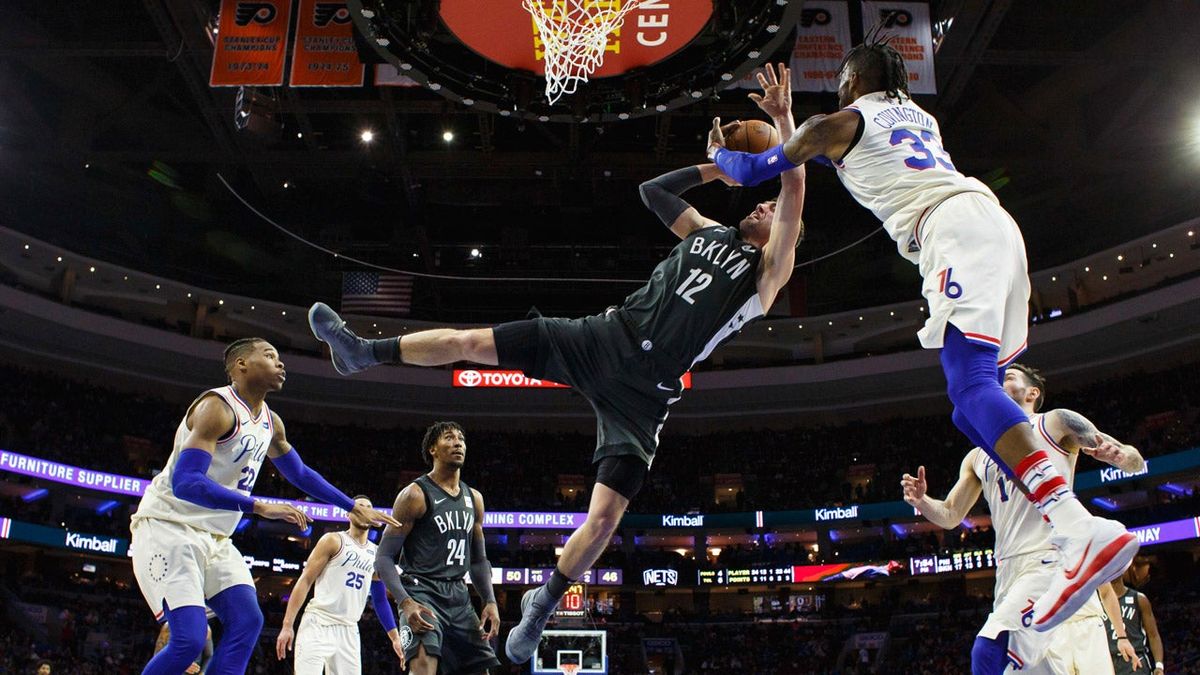 The Sixers’ Robert Covington blocks the Nets’ Joe Harris during last night’s game.
