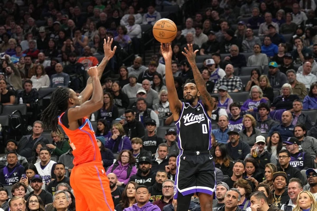 Dec 14, 2023; Sacramento, California, USA; Sacramento Kings guard Malik Monk (0) shoots against Oklahoma City Thunder guard Cason Wallace (left) during the second quarter at Golden 1 Center.
