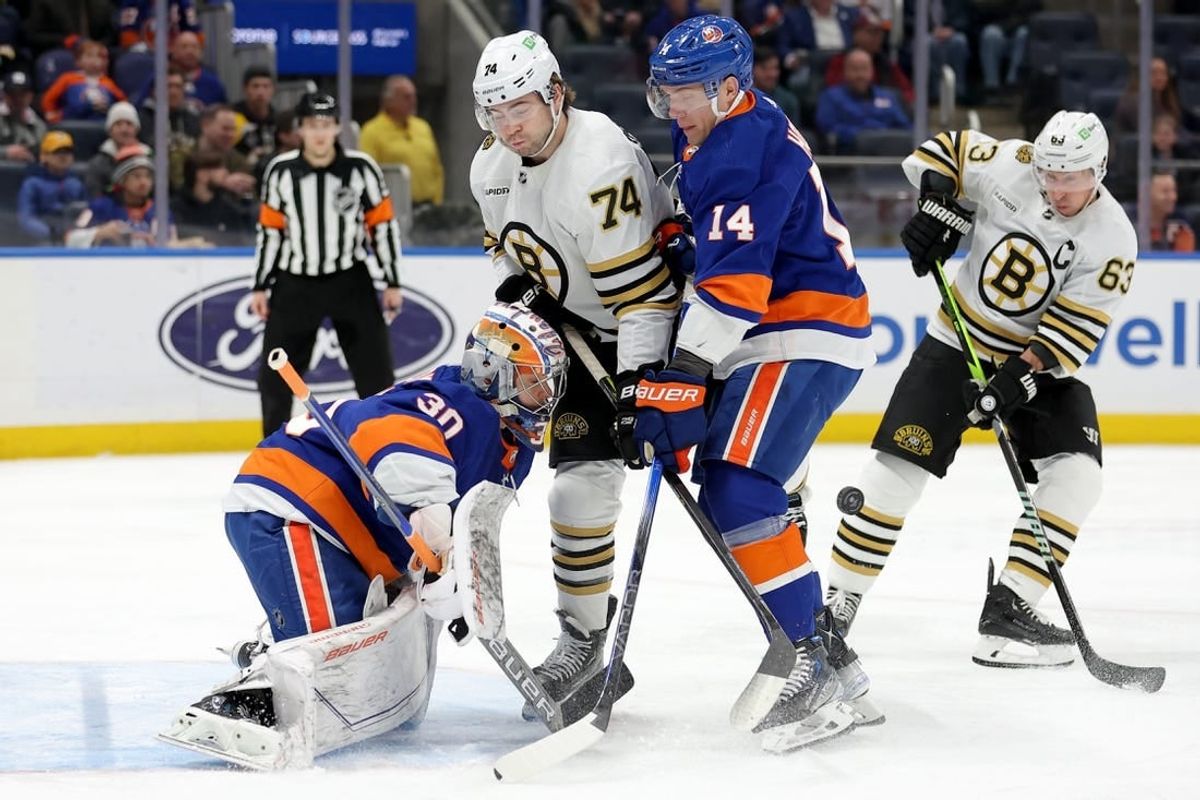 Dec 15, 2023; Elmont, New York, USA; Boston Bruins left wing Jake DeBrusk (74) and left wing Brad Marchand (63) fight for the puck against New York Islanders goaltender Ilya Sorokin (30) and center Bo Horvat (14) during the first period at UBS Arena.