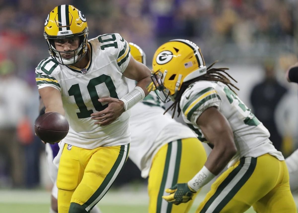 Dec 31, 2023; Minneapolis, Minnesota, USA; Green Bay Packers quarterback Jordan Love (10) hands off the ball to running back Aaron Jones (33) against the Minnesota Vikings during their game at U.S. Bank Stadium.