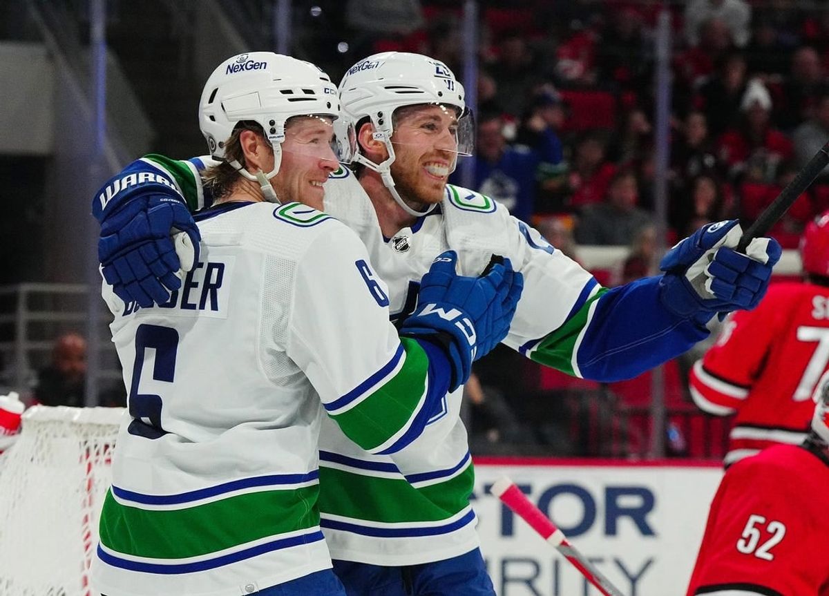 Feb 6, 2024; Raleigh, North Carolina, USA; Vancouver Canucks center Elias Lindholm (23) is congratulated by  right wing Brock Boeser (6) after his goal against the Carolina Hurricanes during the second period at PNC Arena.