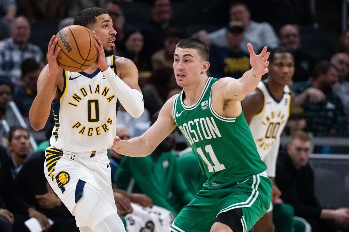 Jan 8, 2024; Indianapolis, Indiana, USA; Indiana Pacers guard Tyrese Haliburton (0) looks to pass the ball while Boston Celtics guard Payton Pritchard (11) defends in the first half at Gainbridge Fieldhouse.