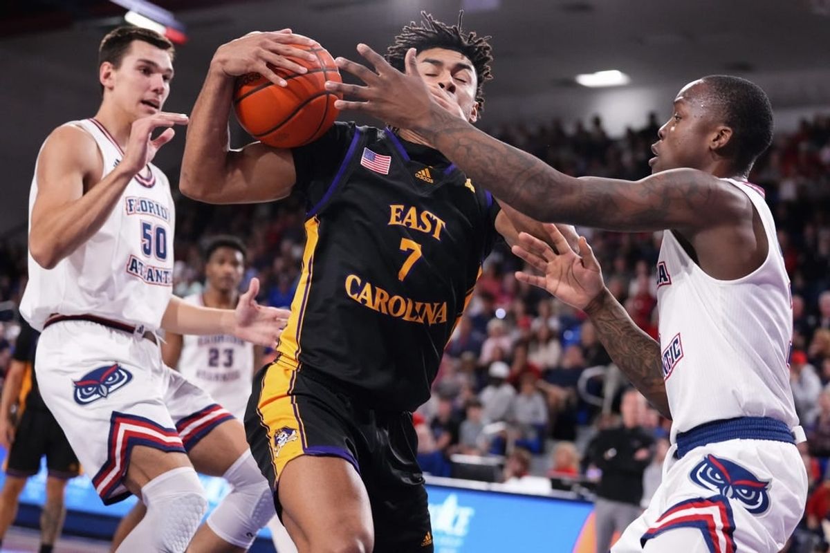 Jan 2, 2024; Boca Raton, Florida, USA; East Carolina Pirates guard Quentin Diboundje (7) dribbles against Florida Atlantic Owls guard Johnell Davis (1) during the first half at Eleanor R. Baldwin Arena.
