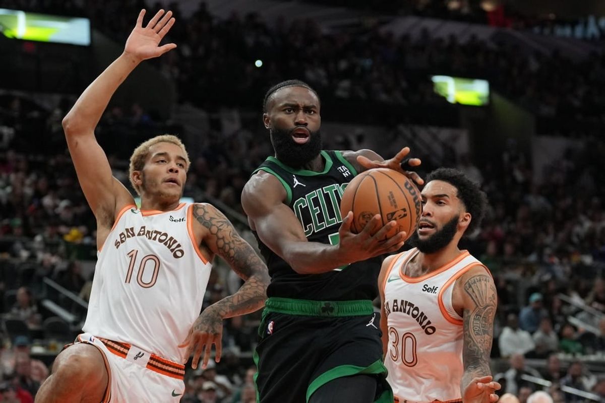Dec 31, 2023; San Antonio, Texas, USA;  Boston Celtics guard Jaylen Brown (7) loses the ball in front of San Antonio Spurs forwards Jeremy Sochan (10) Julian Champagnie (30) in the first half at Frost Bank Center.