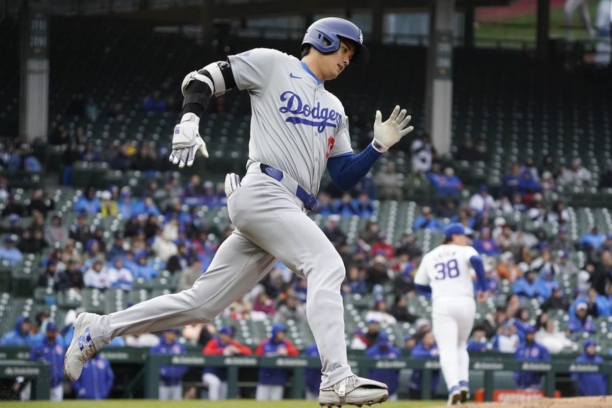 Apr 7, 2024; Chicago, Illinois, USA; Los Angeles Dodgers designated hitter Shohei Ohtani (17) hits a triple against the Chicago Cubs during the sixth inning at Wrigley Field.