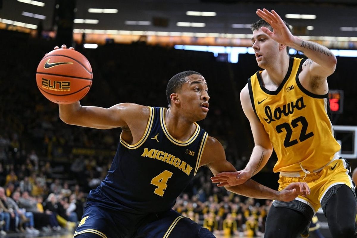 Dec 10, 2023; Iowa City, Iowa, USA; Michigan Wolverines guard Nimari Burnett (4) controls the ball as Iowa Hawkeyes forward Patrick McCaffery (22) defends during the first half at Carver-Hawkeye Arena.