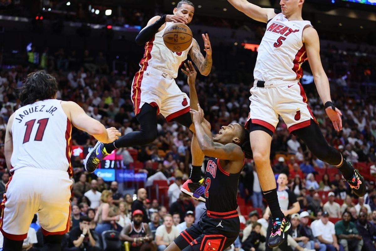 Apr 19, 2024; Miami, Florida, USA; Chicago Bulls guard Ayo Dosunmu (12) reacts after driving to the basket against Miami Heat forward Caleb Martin (16) and forward Nikola Jovic (5) in the second quarter during a play-in game of the 2024 NBA playoffs at Kaseya Center.