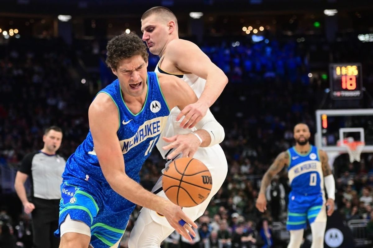Feb 12, 2024; Milwaukee, Wisconsin, USA;  Milwaukee Bucks center Brook Lopez (11) tries to get past Denver Nuggets center Nikola Jokic (15) in the first quarter at Fiserv Forum.