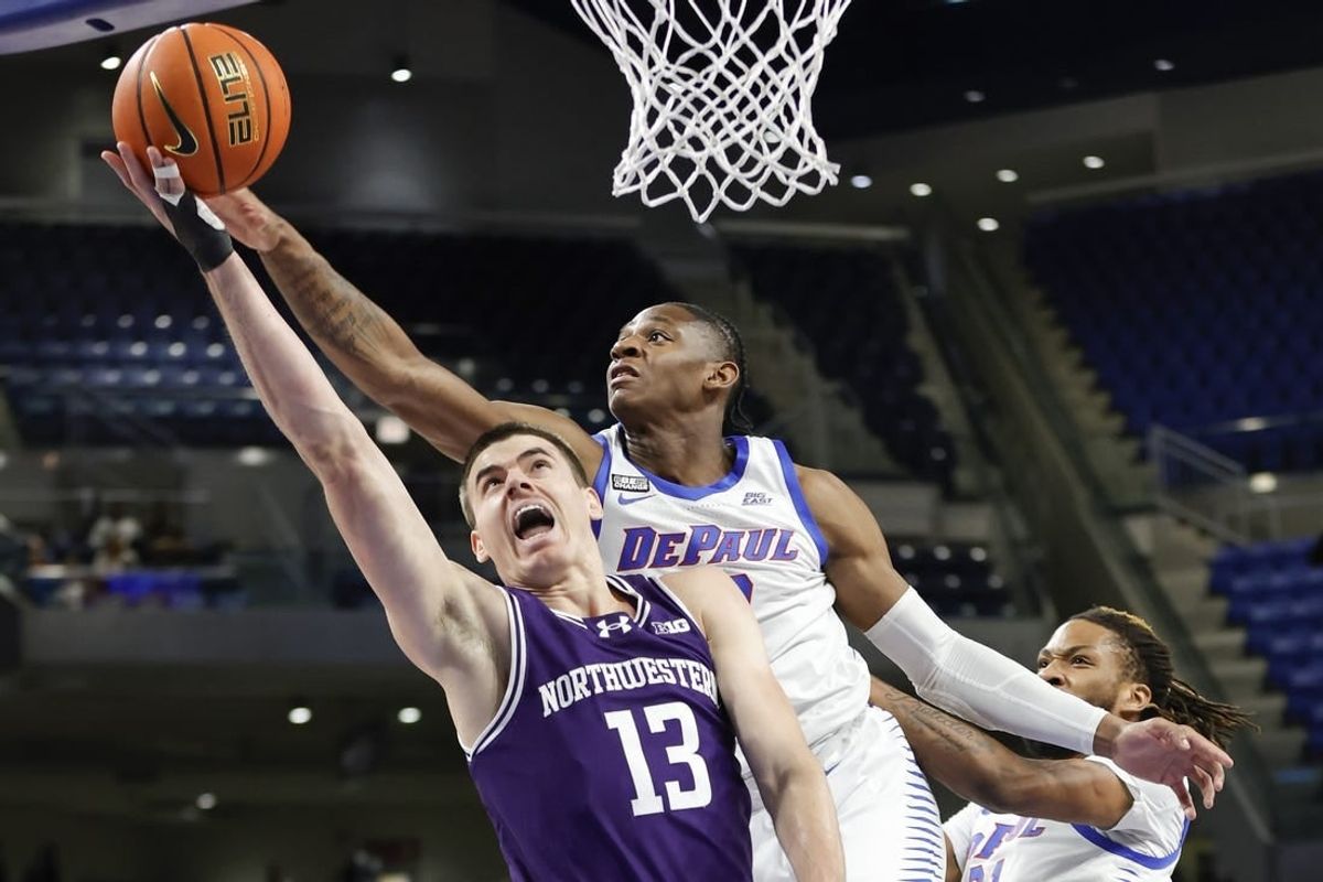 Dec 16, 2023; Chicago, Illinois, USA; Northwestern Wildcats guard Brooks Barnhizer (13) goes to the basket against DePaul Blue Demons guard Elijah Fisher (22) during the first half at Wintrust Arena.