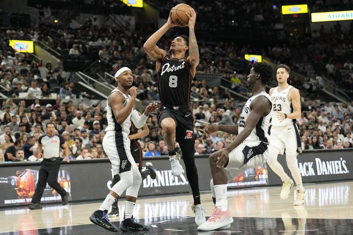 Apr 14, 2024; San Antonio, Texas, USA; Detroit Pistons guard Jared Rhoden (8) drives to the basket between San Antonio Spurs guards Davonte' Graham (4) and Sidy Cissoko (25) during the first half at Frost Bank Center.