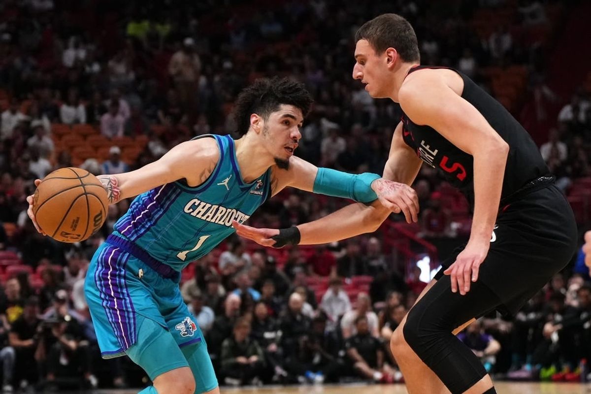 Jan 14, 2024; Miami, Florida, USA; Charlotte Hornets guard LaMelo Ball (1) drives the ball around Miami Heat forward Nikola Jovic (5) during the first half at Kaseya Center.