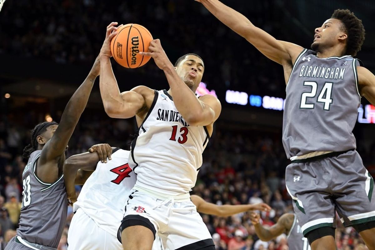 Mar 22, 2024; Spokane, WA, USA; San Diego State Aztecs forward Jaedon LeDee (13) rebounds the ball against UAB Blazers guard Efrem Johnson (24)  during the second half in the first round of the 2024 NCAA Tournament at Spokane Veterans Memorial Arena.