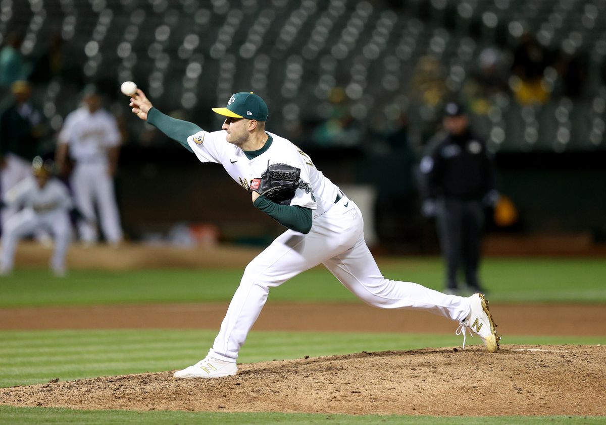Scores of empty seats can be seen in background of As pitcher Ryan Castellani.