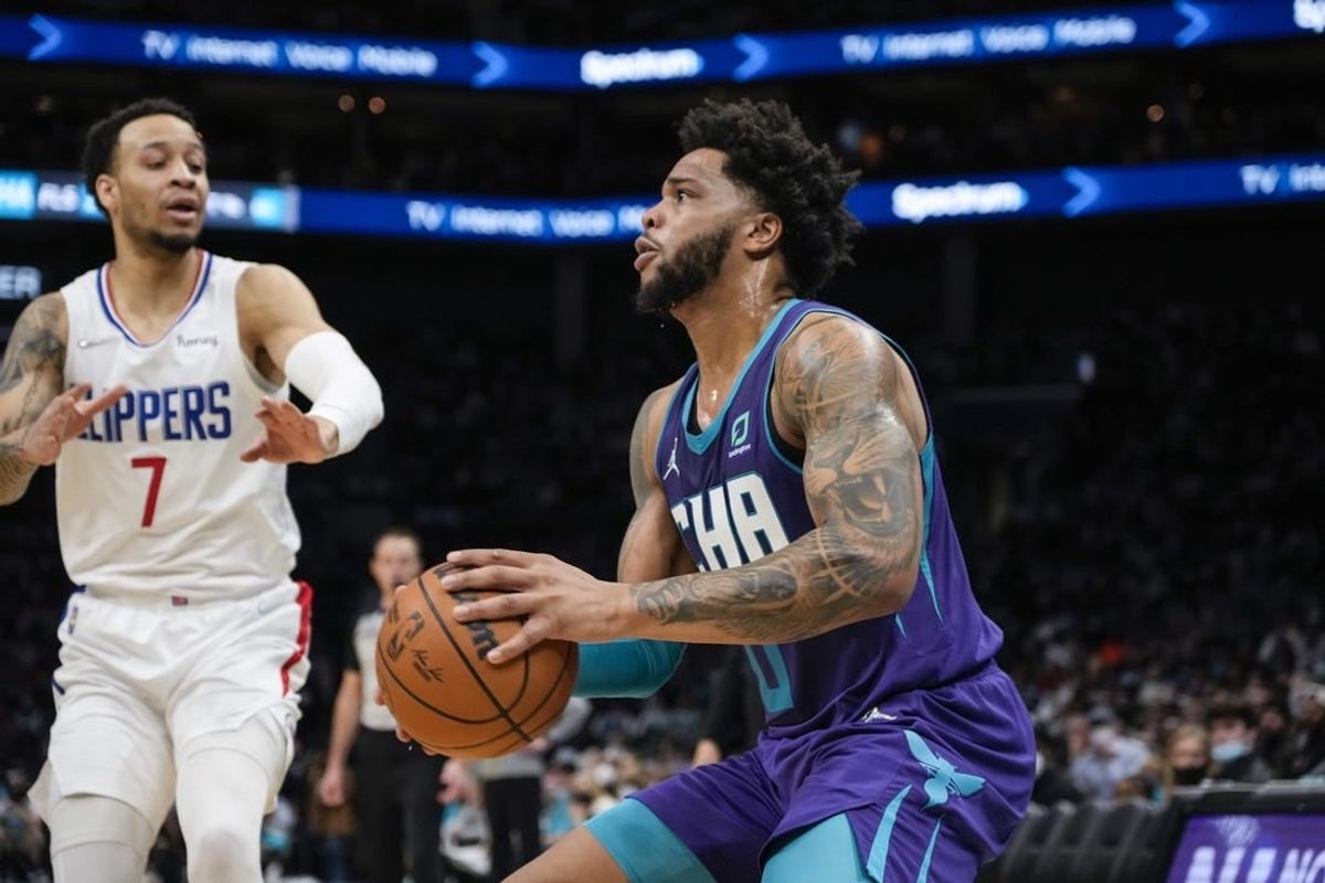 Jan 30, 2022; Charlotte, North Carolina, USA; Charlotte Hornets forward Miles Bridges (0) pulls up for a jumper defended by LA Clippers guard Amir Coffey (7) during the second quarter at the Spectrum Center.