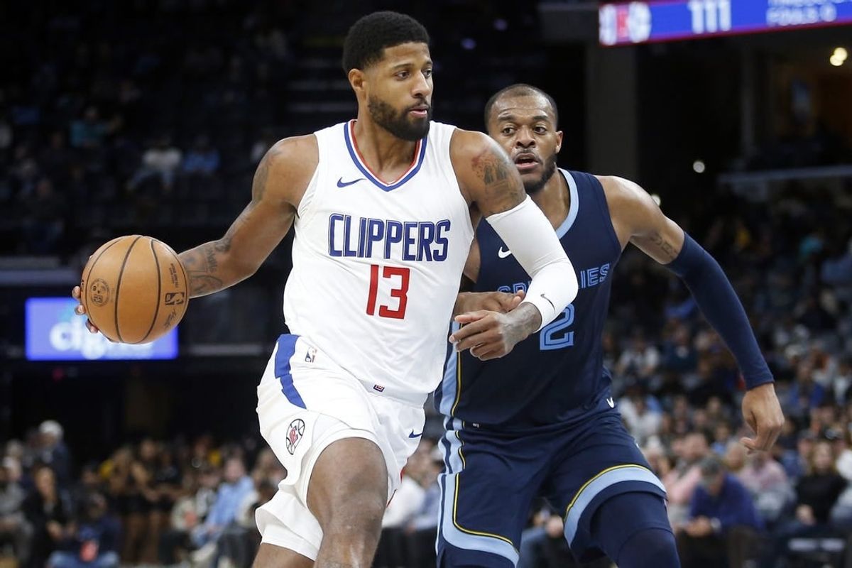 Jan 12, 2024; Memphis, Tennessee, USA; Los Angeles Clippers forward Paul George (13) drives to the basket as Memphis Grizzlies forward Xavier Tillman (2) defends during the second half at FedExForum.
