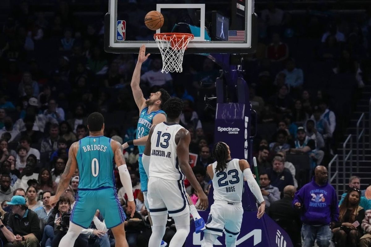 Feb 10, 2024; Charlotte, North Carolina, USA; Charlotte Hornets guard Vasilije Micic (22) with a reverse layup defended by Memphis Grizzlies guard Derrick Rose (23) during the second half at Spectrum Center.