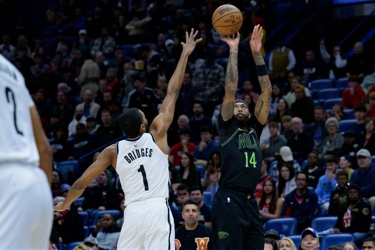 Jan 2, 2024; New Orleans, Louisiana, USA;  New Orleans Pelicans forward Brandon Ingram (14) shoots a three point basket against Brooklyn Nets forward Mikal Bridges (1) at Smoothie King Center.