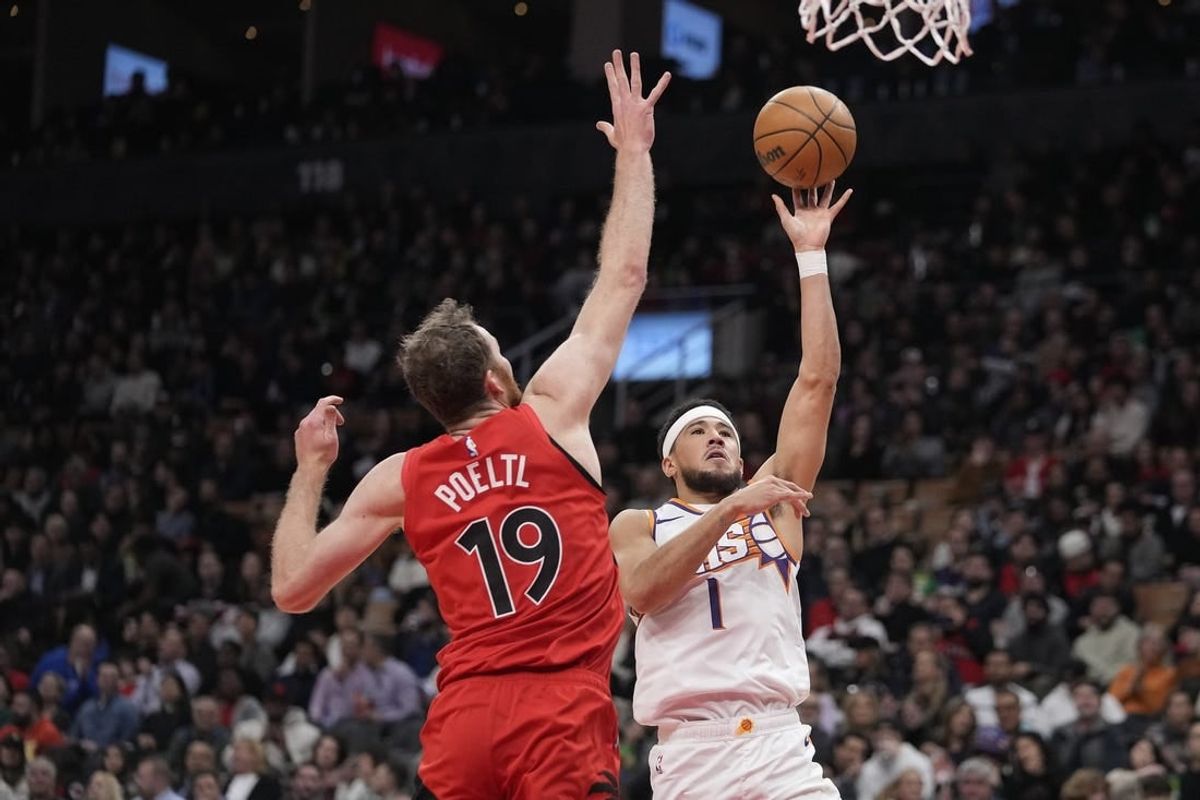 Nov 29, 2023; Toronto, Ontario, CAN; Phoenix Suns guard Devin Booker (1) shoots the ball as Toronto Raptors center Jakob Poeltl (19) defends during the first half at Scotiabank Arena.