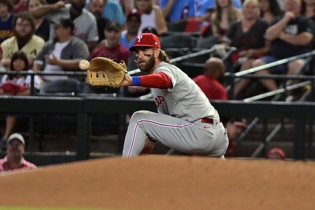Oct 19, 2023; Phoenix, Arizona, USA; Philadelphia Phillies first baseman Bryce Harper (3) gets an out at first base against the Arizona Diamondbacks in the first inning during game three of the NLCS for the 2023 MLB playoffs at Chase Field.