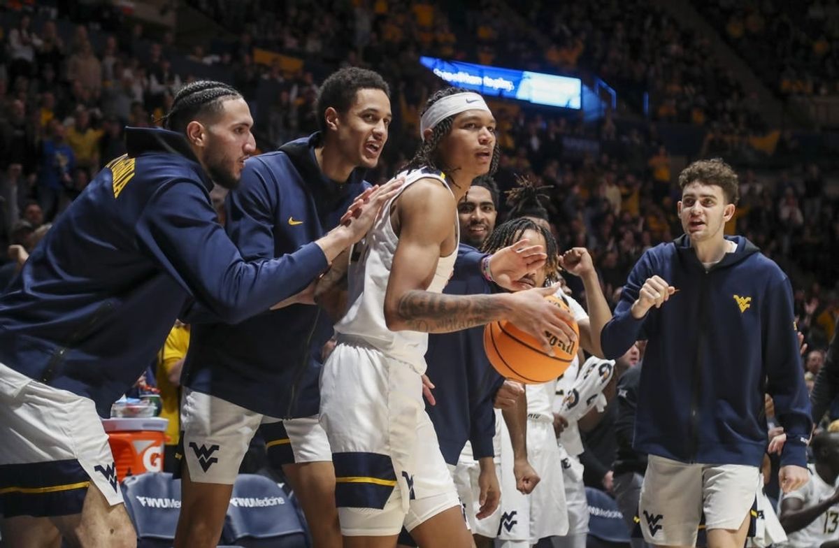 Jan 20, 2024; Morgantown, West Virginia, USA; West Virginia Mountaineers guard RaeQuan Battle (21) is greeted by teammates after a play during the second half against the Kansas Jayhawks at WVU Coliseum.