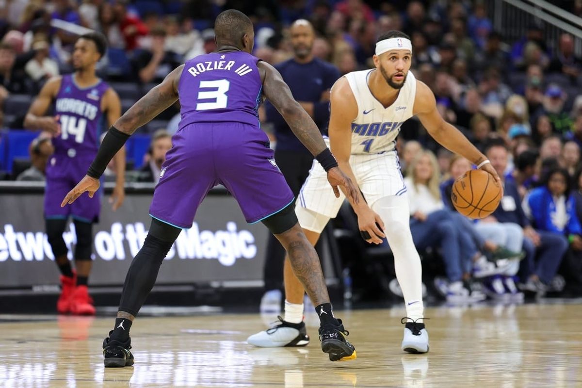 Nov 26, 2023; Orlando, Florida, USA;  Orlando Magic guard Jalen Suggs (4) is guarded by Charlotte Hornets guard Terry Rozier (3) in the second quarter at Amway Center.