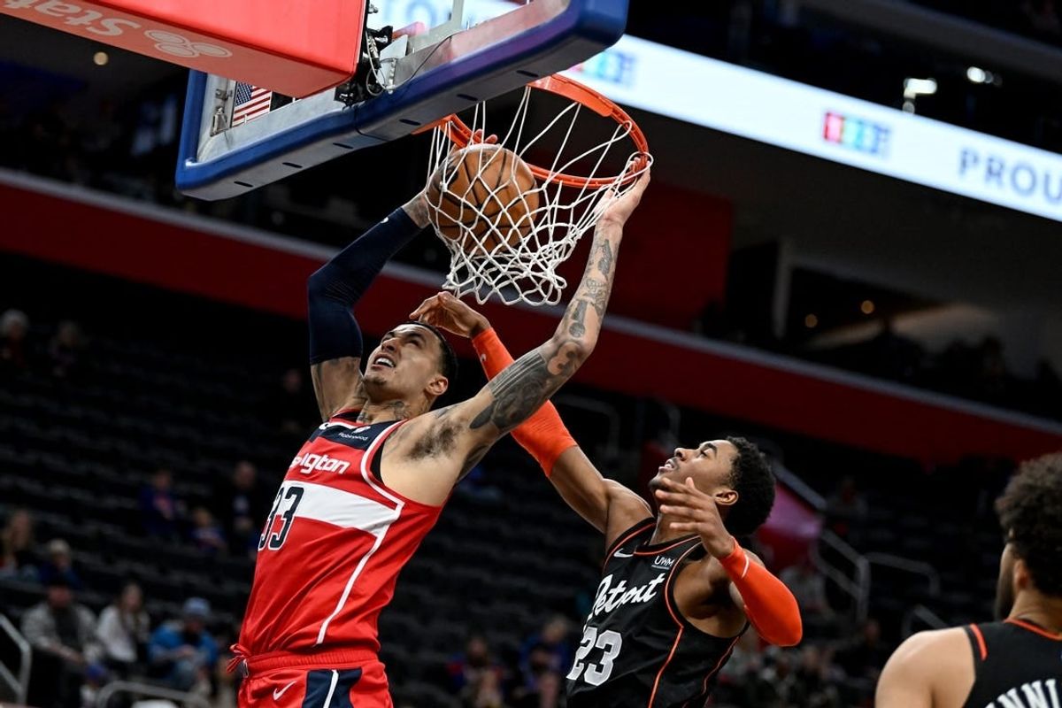 Jan 27, 2024; Detroit, Michigan, USA; Washington Wizards forward Kyle Kuzma (33) dunks the ball over Detroit Pistons guard Jaden Ivey (23) in the fourth quarter at Little Caesars Arena.