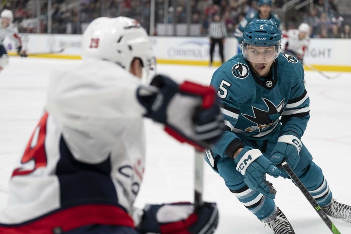 Nov 27, 2023; San Jose, California, USA; San Jose Sharks defenseman Matt Benning (5) defends against Washington Capitals center Hendrix Lapierre (29) during the third period at SAP Center at San Jose.