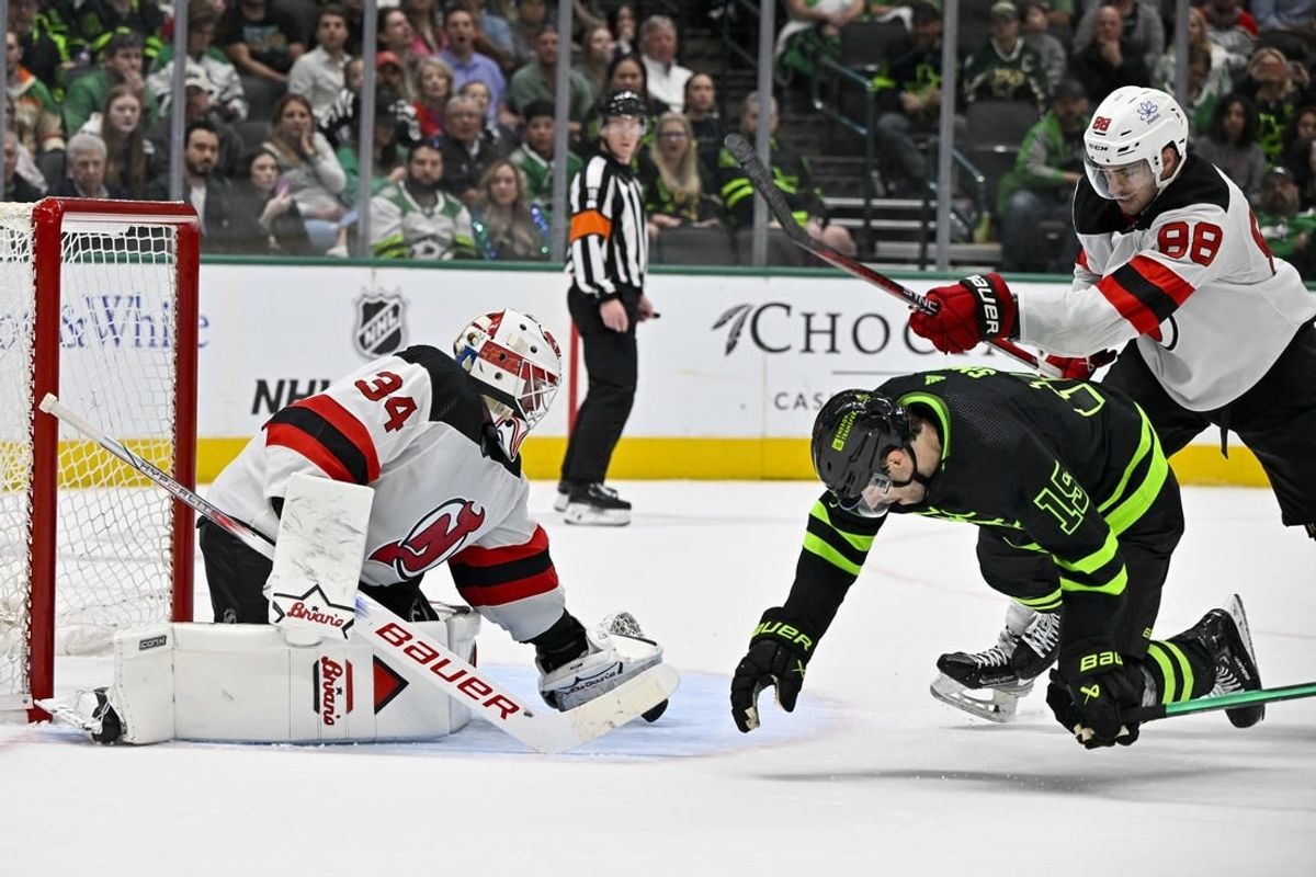 Mar 14, 2024; Dallas, Texas, USA; New Jersey Devils defenseman Kevin Bahl (88) is called for a cross check on Dallas Stars left wing Jamie Benn (14) as goaltender Jake Allen (34) covers the puck during the second period at the American Airlines Center.