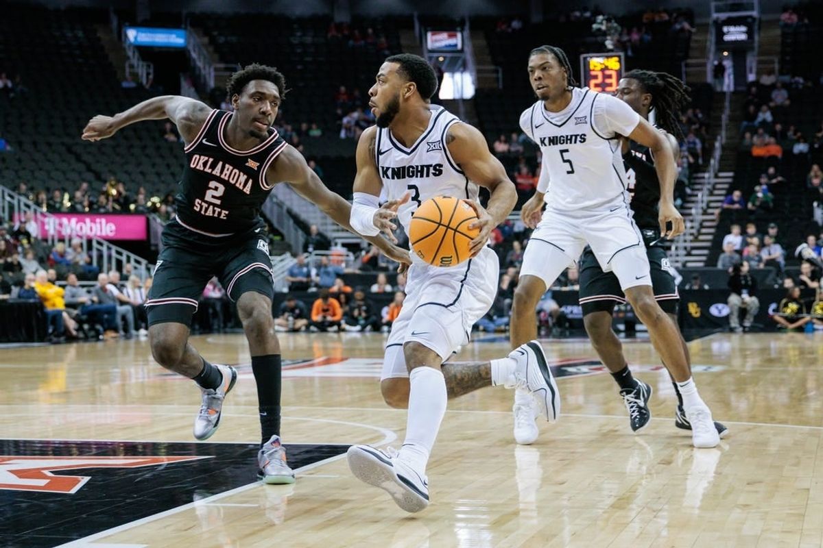 Mar 12, 2024; Kansas City, MO, USA; UCF Knights guard Darius Johnson (3) drives to the basket around Oklahoma State Cowboys forward Eric Dailey Jr. (2) during the first half at T-Mobile Center.